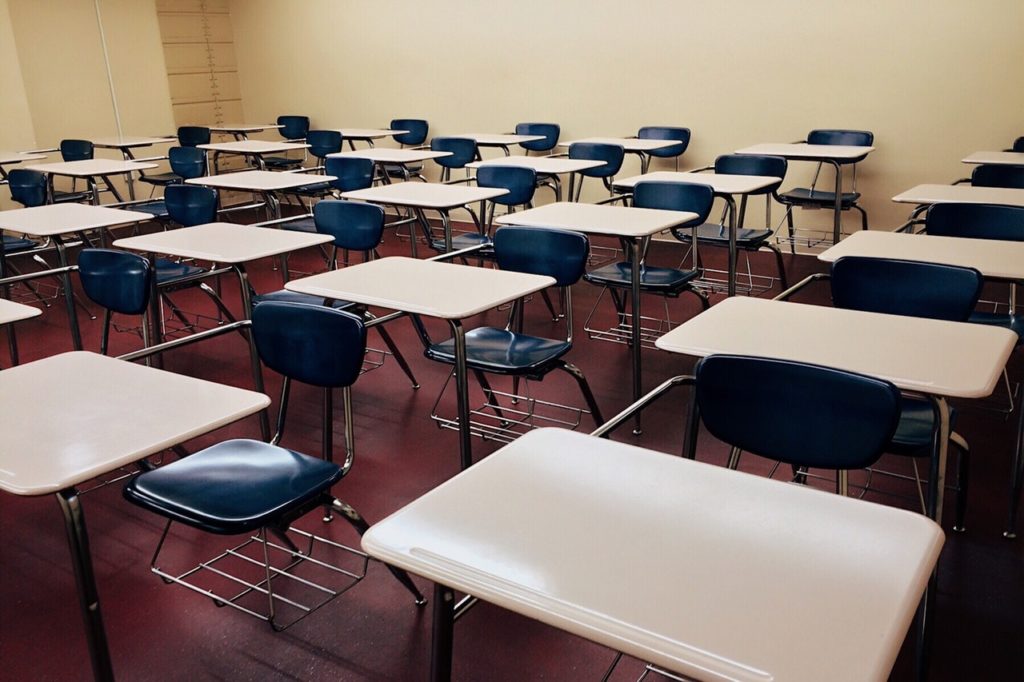 empty classroom with desks and blue chairs