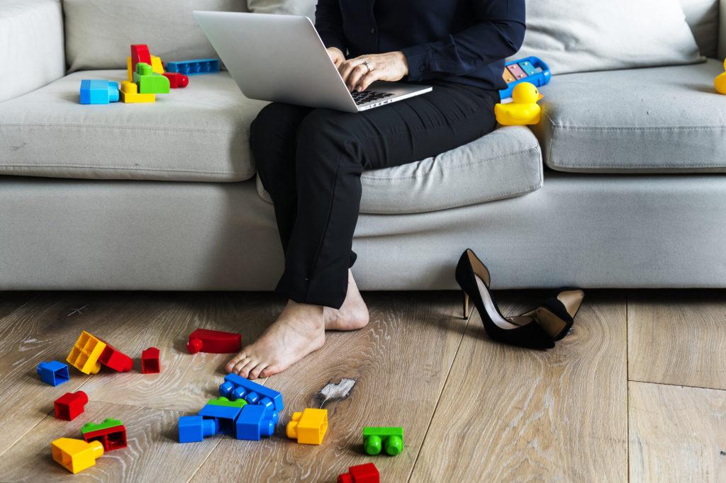 Woman working on laptop on sofa
