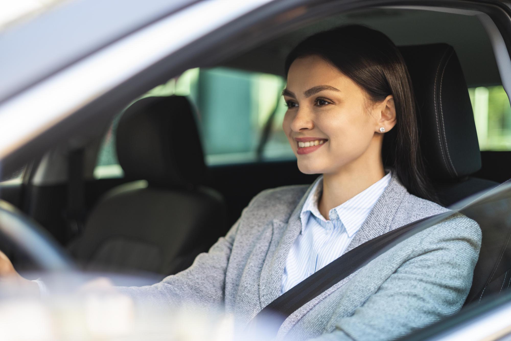 Smiley business woman driving her car Smiley business woman driving her car